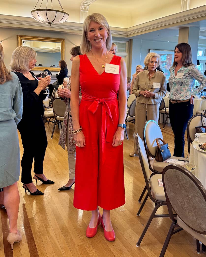 Woman in red jumpsuit wearing Lava Red PIAR Performance Heels at luncheon event