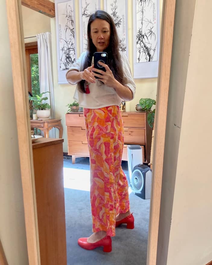 Woman wearing PIAR Performance Heels in Lava Red, taking mirror selfie in living room