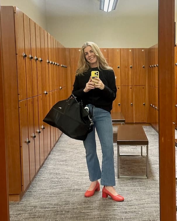 Woman wearing PIAR Performance Heels in Lava Red, taking mirror selfie in locker room
