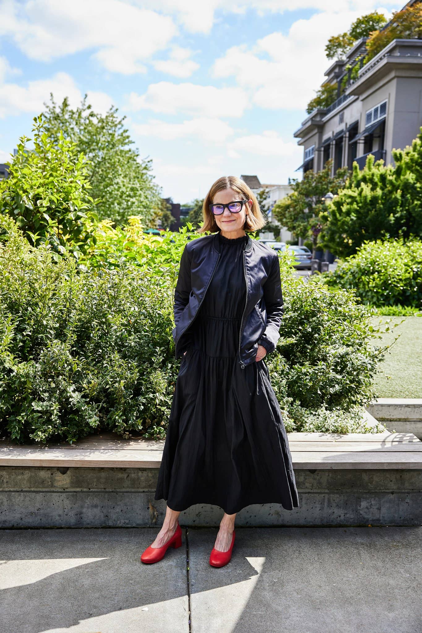 Caroline Hughes wearing Lava Red PIAR Performance Heels and a black dress outdoors