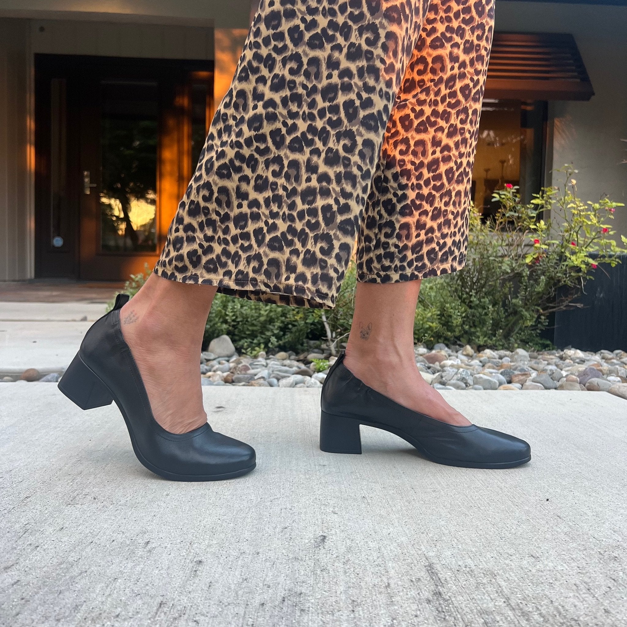 The Performance Heel by PIAR - Woman Wearing Stylish and Comfortable Black Leather Block Heel Pumps With Leopard Pants