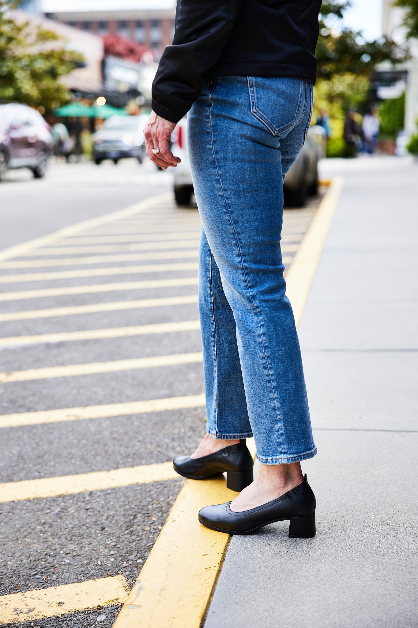 The Performance Heel by PIAR - Woman Wearing Stylish and Comfortable Black Leather Block Pumps Standing on Yellow Curb