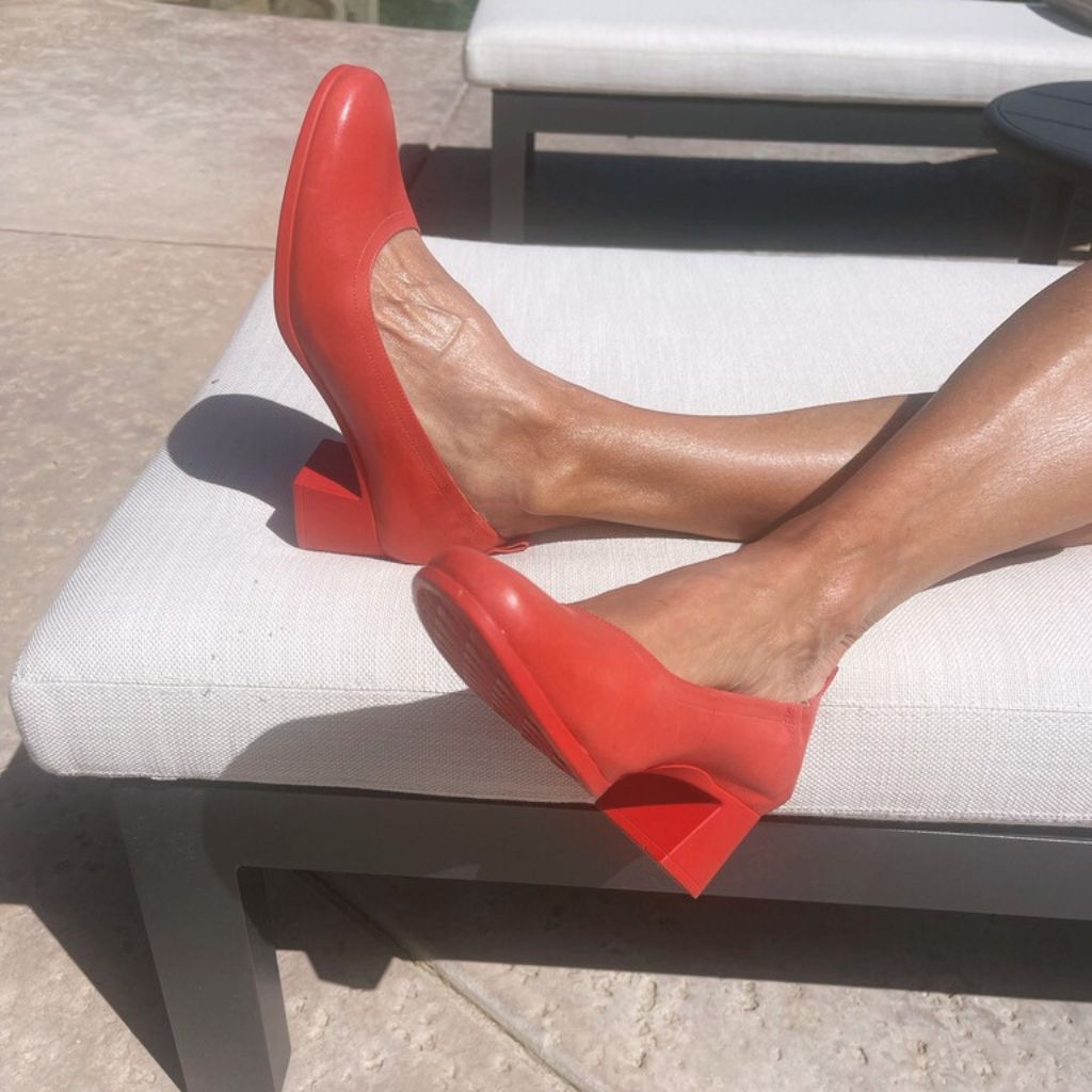 The Performance Heel by PIAR - Woman Wearing Stylish and Comfortable Red Leather Block Heel Pumps Lounging in the Sun